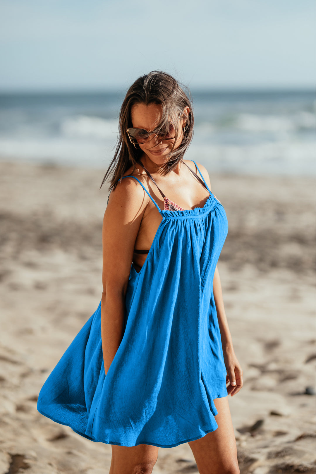 Woman at beach wearing Bette Amalie mini cover up in ocean blue