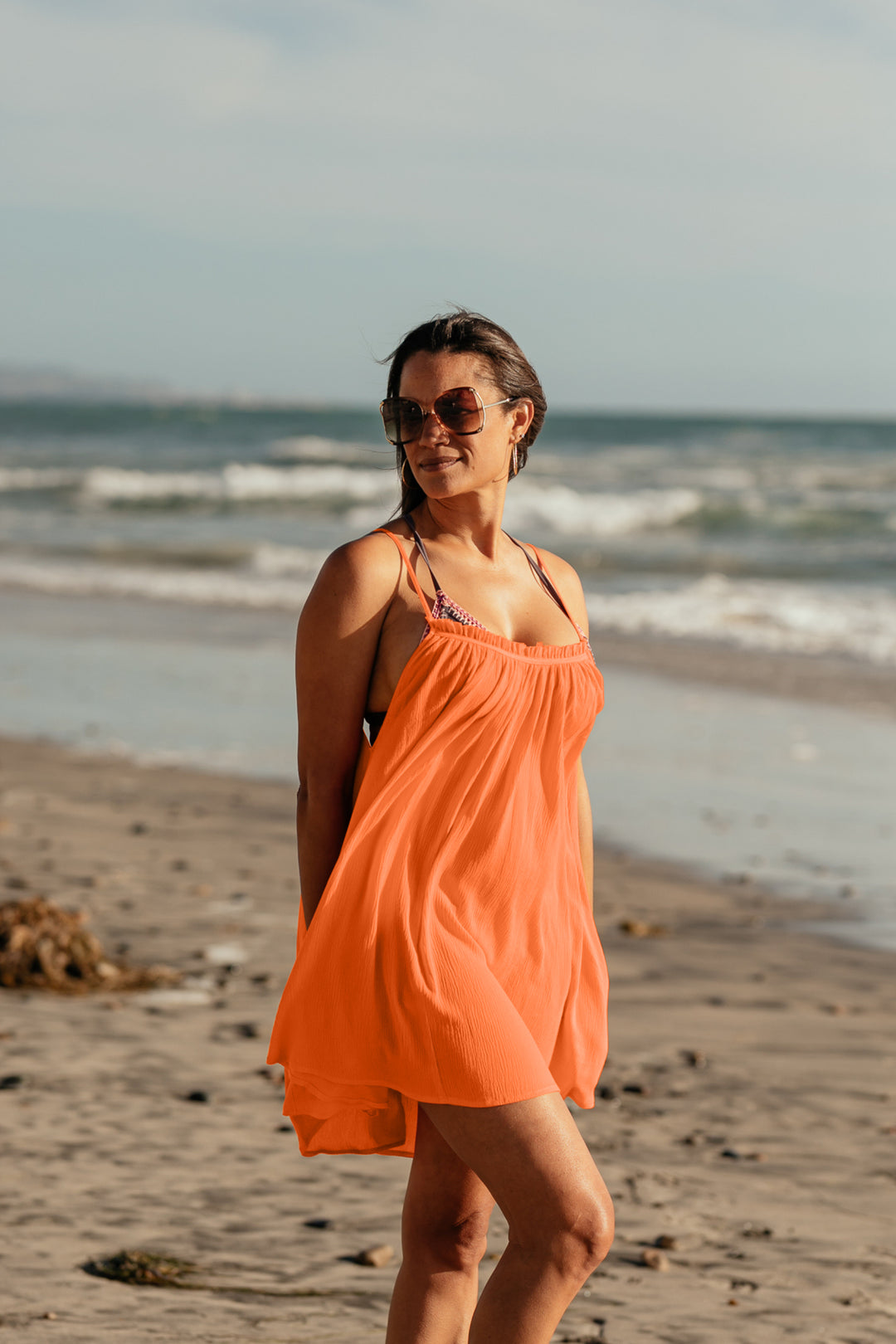 Bette cover up: Woman standing by the ocean wearing Bette's Amalie mini cover up in citrus