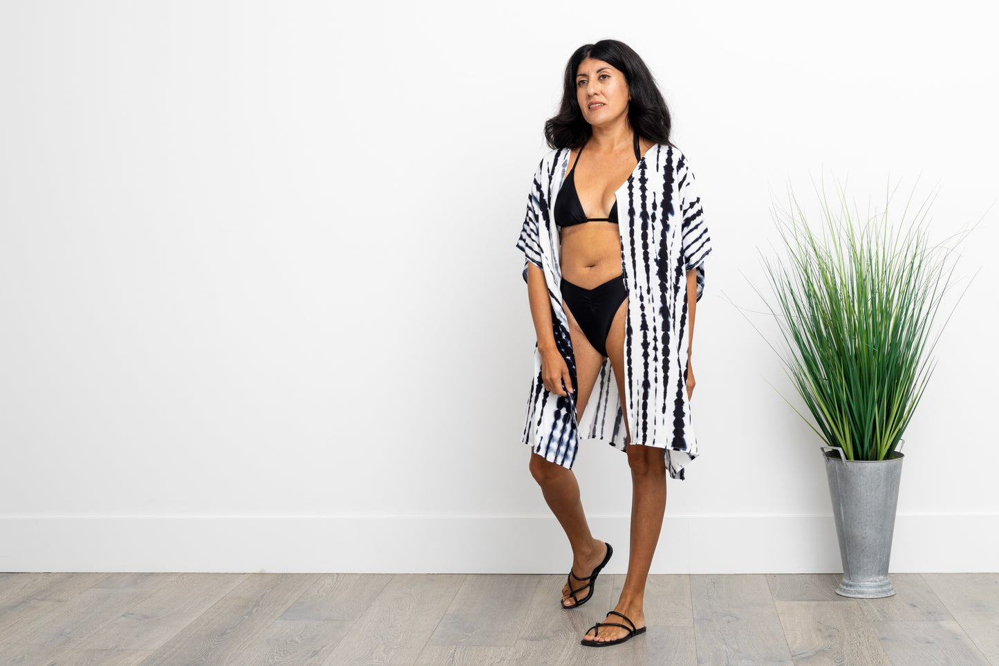 woman in a black bathingsuit wearing a navy blue and white dyed short kimono