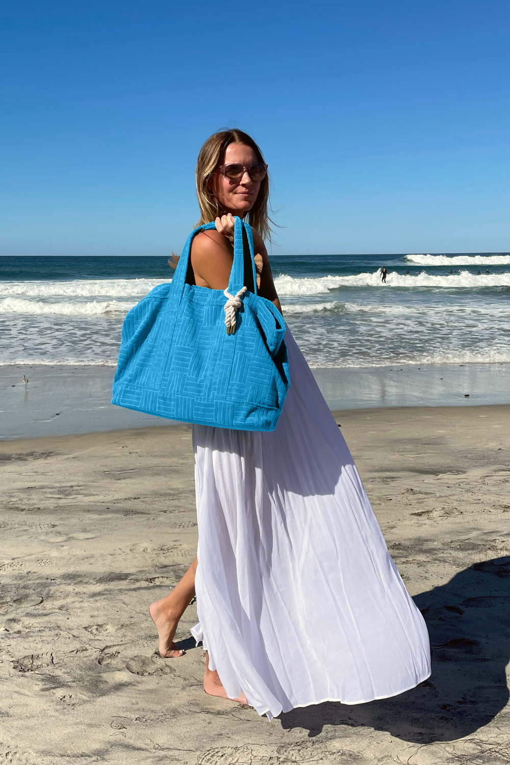 Bette_weekender set_woman on beach with blue beach bag tote