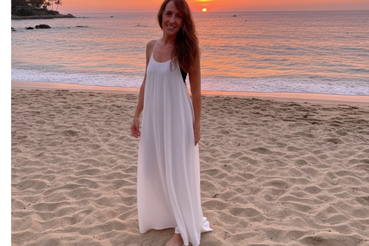 Woman wearing a white linen coverup maxi dress on the beach at sunset
