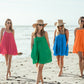 Four women walking at the beach wearing Bette Amalie mini cover ups in 4 colors