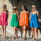 Four women posing at the beach, wearing Bette Amalie mini swimsuit cover ups in multiple colors