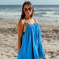 Woman at the beach smiling, wearing Bette Amalie mini cover up in Ocean blue