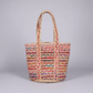 Multicolored woven tote bag on a gray background