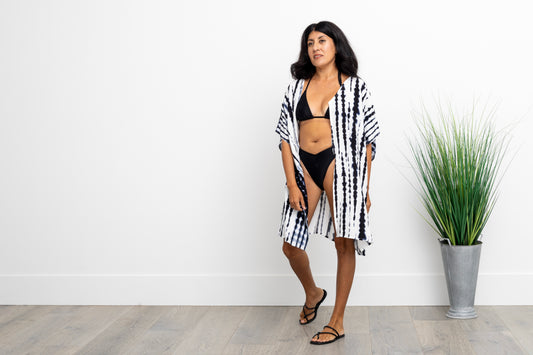 woman in a black bathingsuit wearing a navy blue and white dyed short kimono