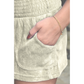 Closeup of a womans hand in a pair of tan terry cloth shorts.