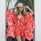 Woman wearing a red and white floral dress and beige hat outdoors