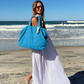 Bette_weekender set_woman on beach with blue beach bag tote