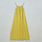 Yellow dress with thin straps on a light gray background