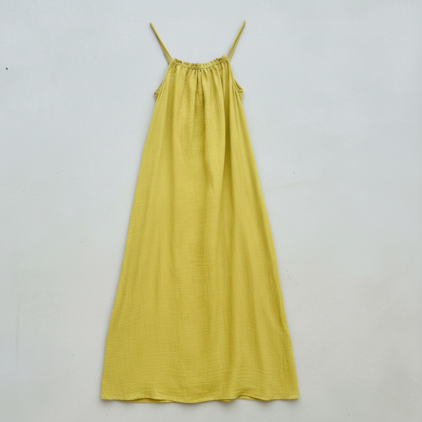 Yellow dress with thin straps on a light gray background