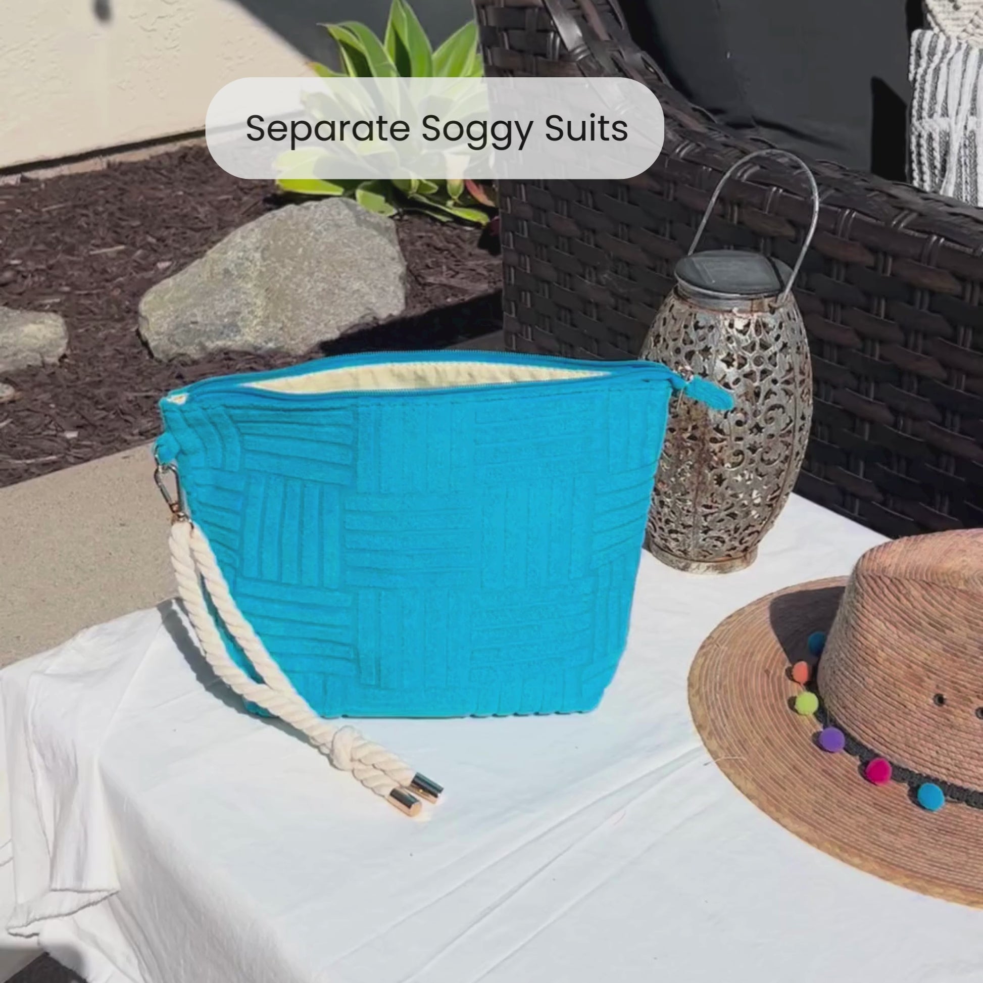 Video of someone putting a wet swimsuit into a blue waterproof bag that is terry cloth on the outside with a rope tassel
