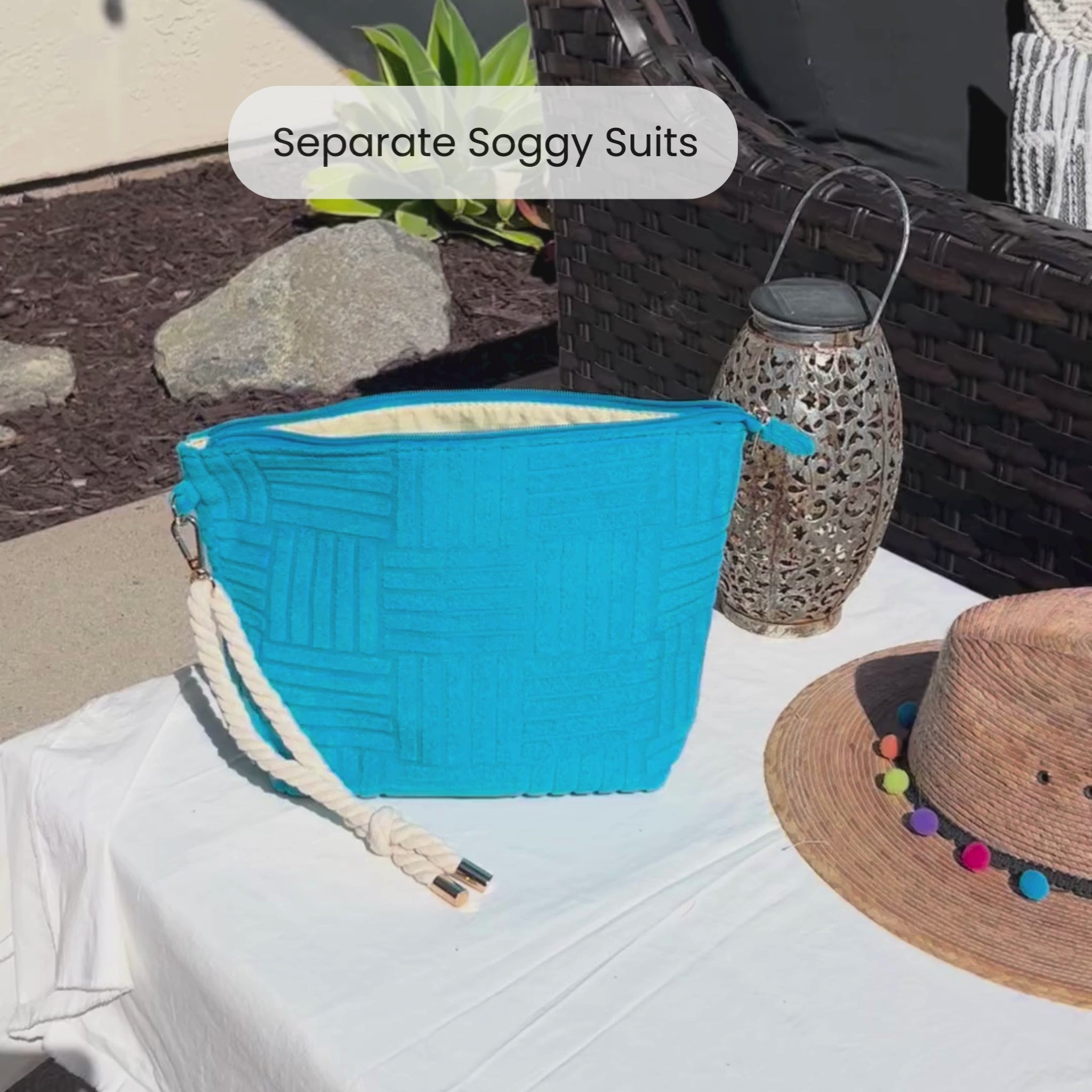 Video of someone putting a wet swimsuit into a blue waterproof bag that is terry cloth on the outside with a rope tassel