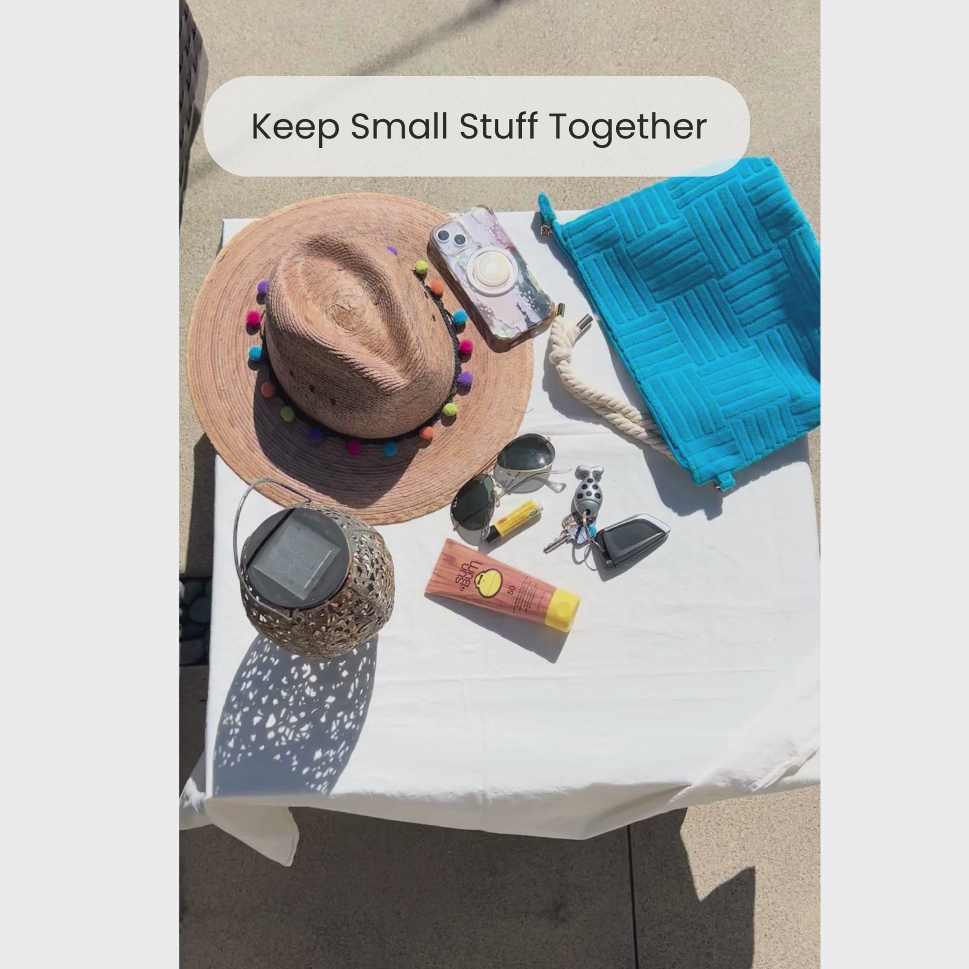 Video of someone packing small essentials into a blue terry cloth pouch with rope tassel
