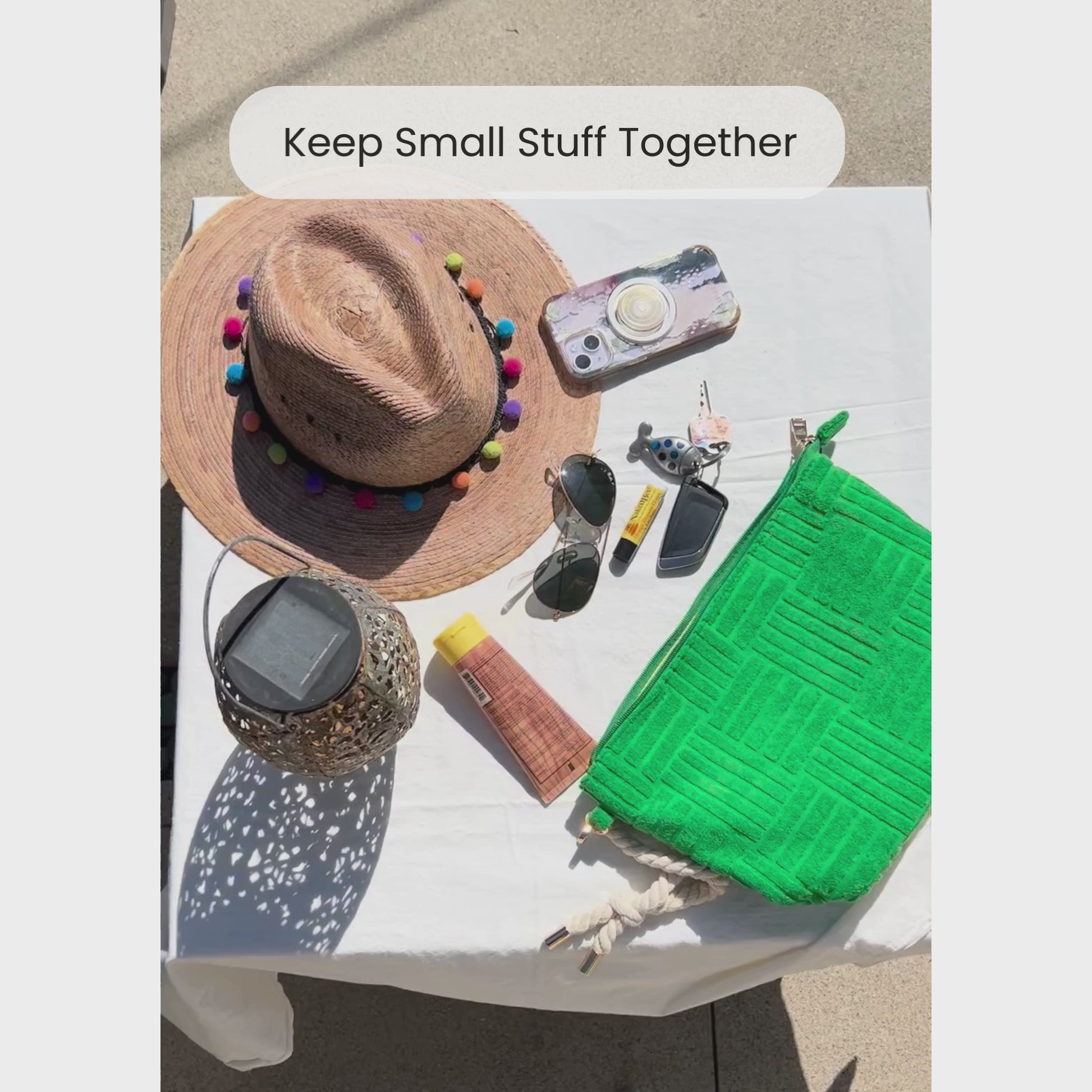 Video of someone packing small essentials into a green terry cloth pouch with rope tassel