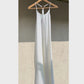 Off white linen dress blowing in the wind on a hanger.