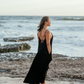 Woman wearing Bette maxi cover up at the beach in California, watching the sun set.