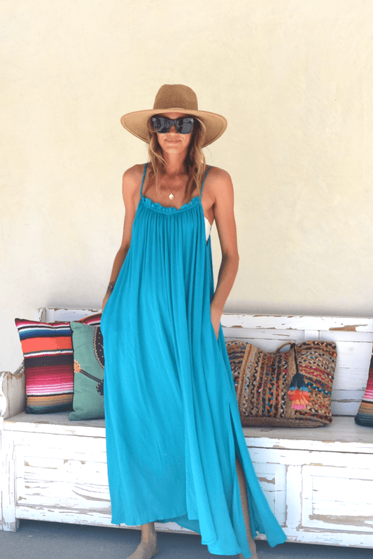 Woman wearing turquoise maxi cover up, paired with hat and sunglasses.